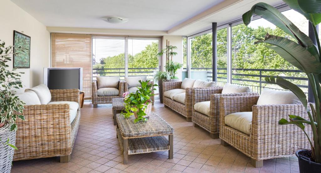 un porche grillagé avec des meubles et des fenêtres en osier dans l'établissement Hotel Sampaoli, à Bellaria-Igea Marina