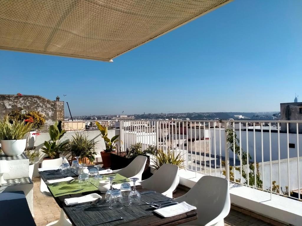 une table et des chaises sur un balcon avec vue dans l'établissement Dar Shâan, à Rabat