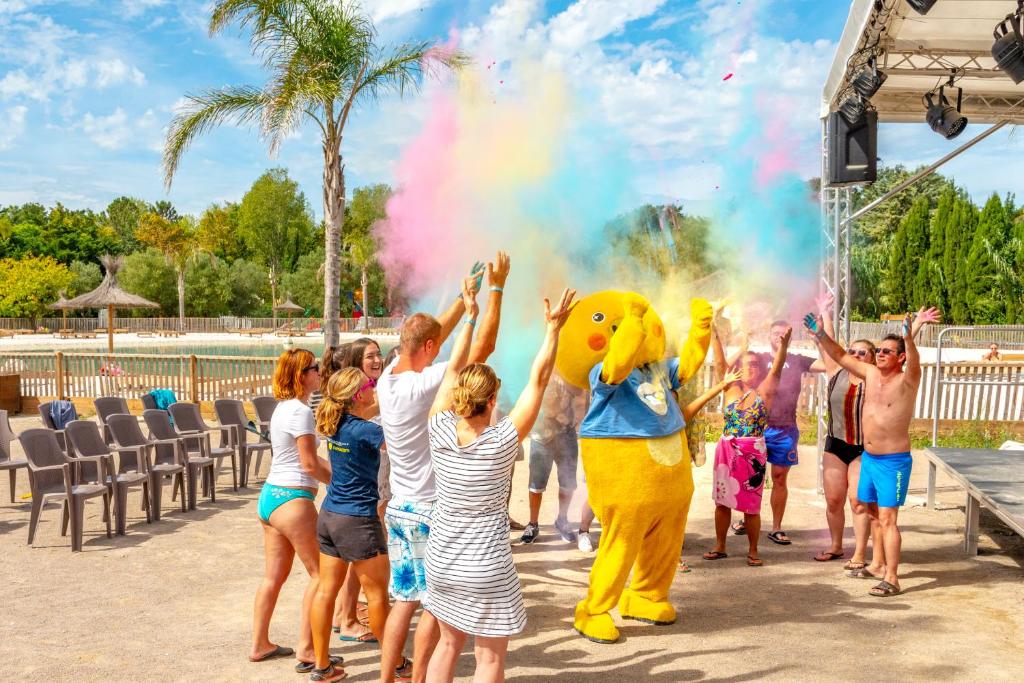 Un groupe d'enfants regardant un groupe de personnes avec une mascotte de canard jaune dans l'établissement Camping maeva Club Le Lagon d'Argelès, à Argelès-sur-Mer 24 autres photos