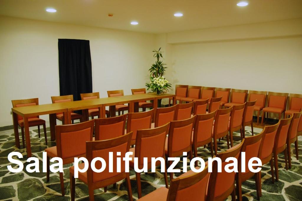 une salle de conférence avec une longue table et des chaises dans l'établissement Casa Rossa 1888, à Torre del Greco