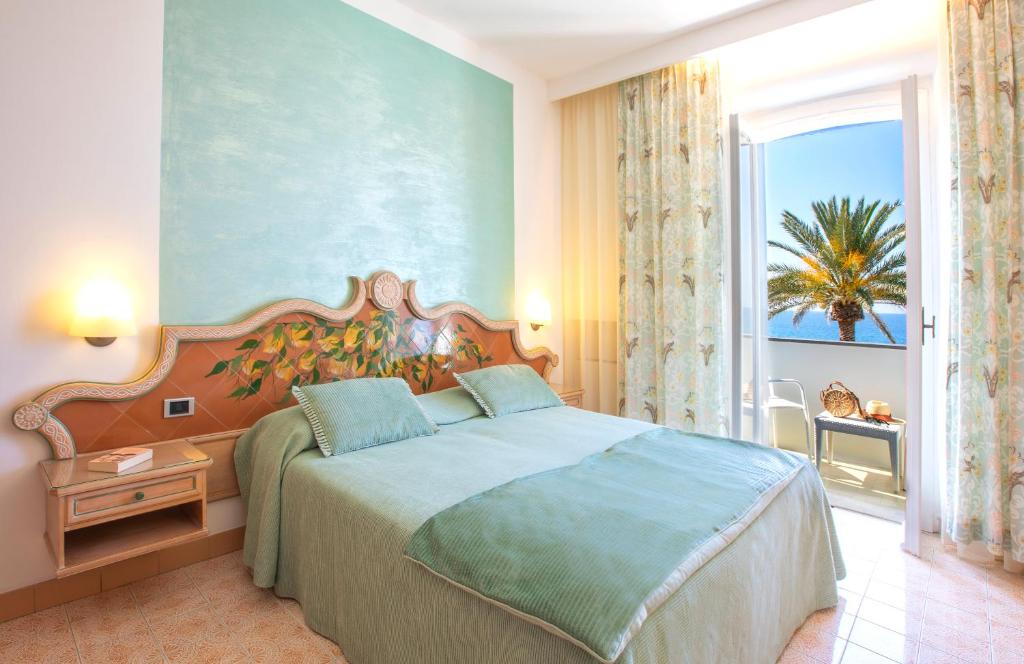 une chambre avec un lit et une grande fenêtre dans l'établissement Hotel Parco Smeraldo Terme, à Ischia