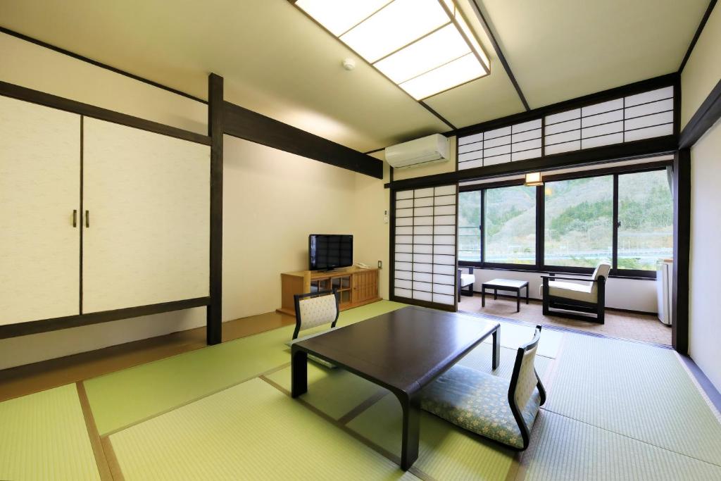 - un salon avec une table, un canapé et une télévision dans l'établissement Matsunoi, à Minakami