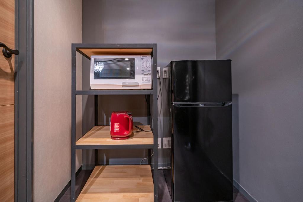 Elle comprend une petite cuisine équipée d'un réfrigérateur noir et d'un four micro-ondes. dans l'établissement 飛騨高山 ホテル デリッシュ, à Takayama
