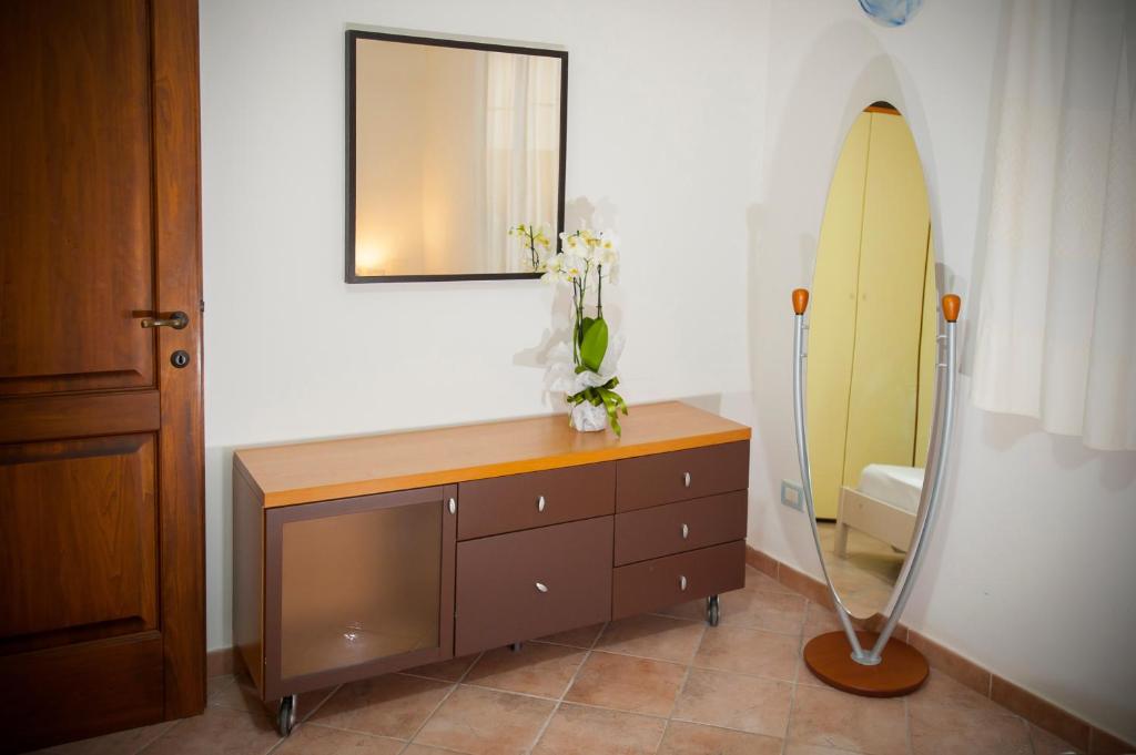 La salle de bains est pourvue d'une commode en bois et d'un miroir. dans l'établissement Villa Isuledda Lux, à San Teodoro