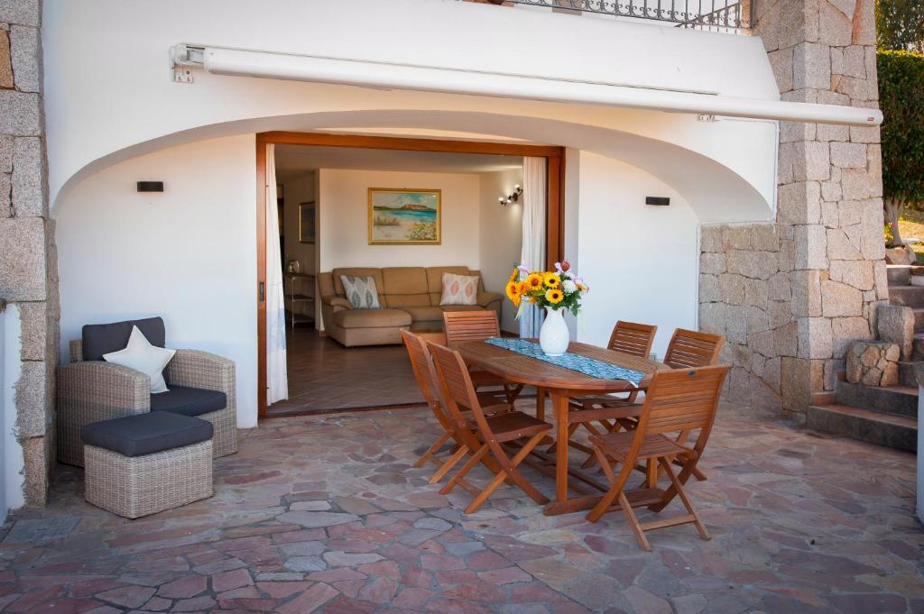 un patio avec une table et des chaises en bois dans l'établissement Villa Isuledda Lux, à San Teodoro