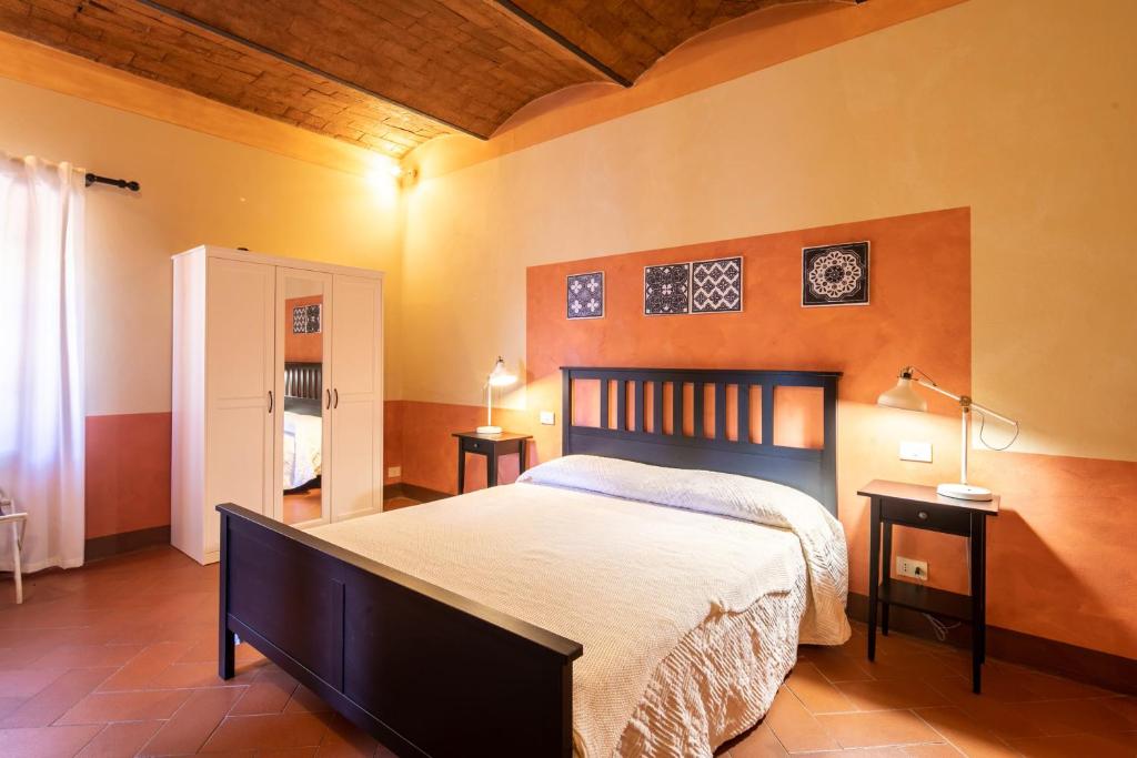 une chambre avec un grand lit et deux tables de nuit dans l'établissement Pieve di Campoli by VacaVilla, à San Donato in Poggio