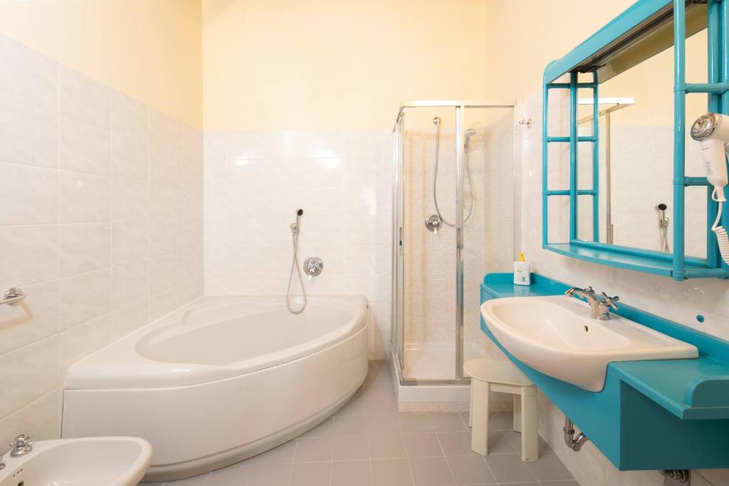 une salle de bain blanche avec une baignoire et un lavabo dans l'établissement Pieve di Campoli by VacaVilla, à San Donato in Poggio