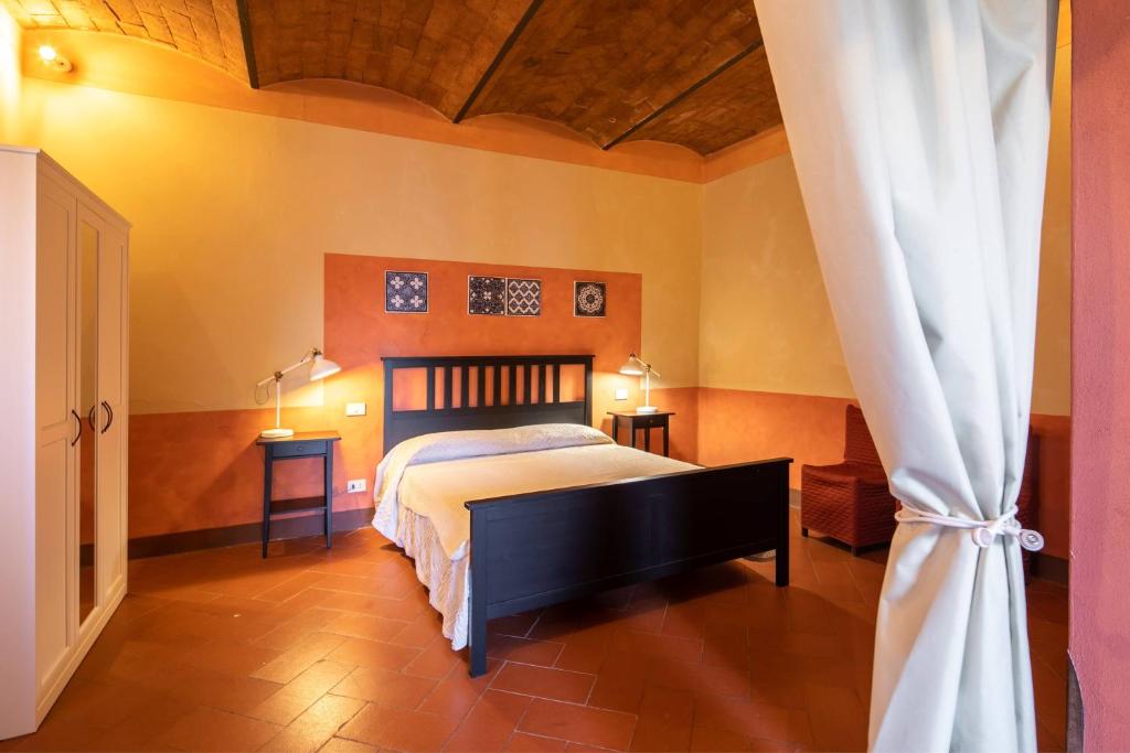 - une chambre avec un lit, deux tables et deux lampes dans l'établissement Pieve di Campoli by VacaVilla, à San Donato in Poggio 35 autres photos