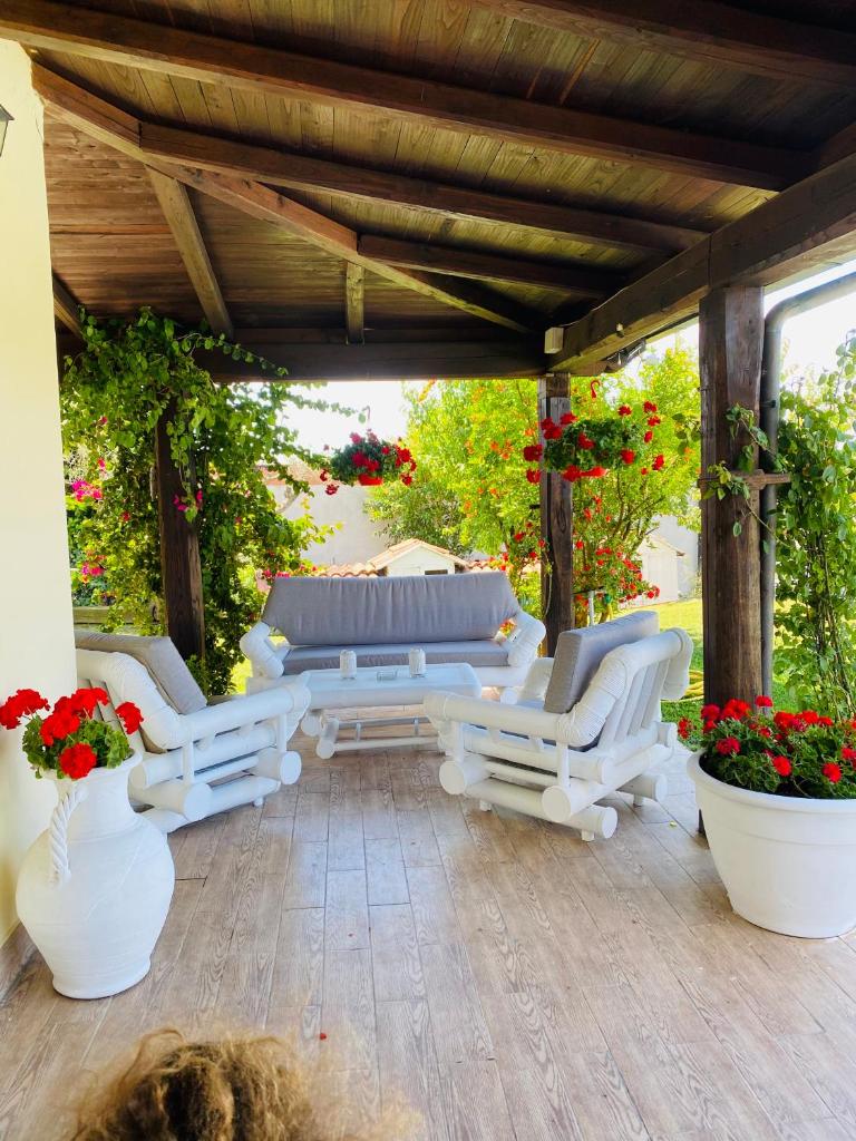 d'une terrasse avec des chaises blanches, une table et des fleurs. dans l'établissement Chanel Garden Relaxation Home, à Formello