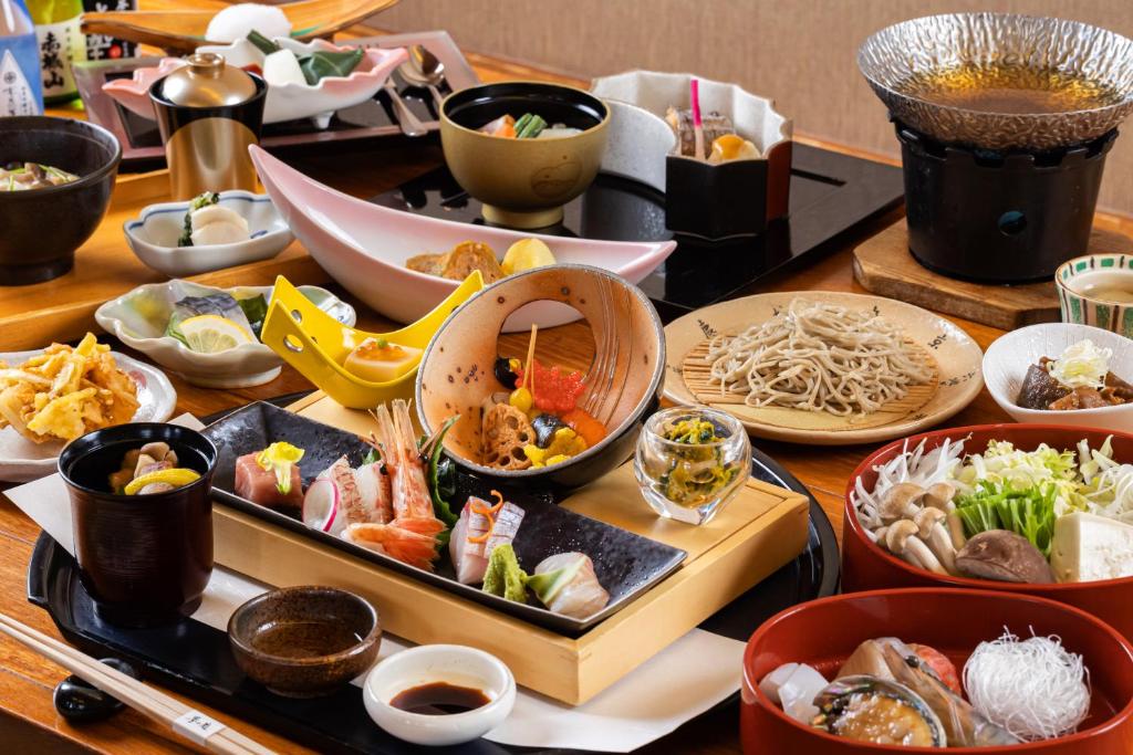 une table avec des assiettes et des bols de nourriture dans l'établissement Tokinoniwa, à Kusatsu