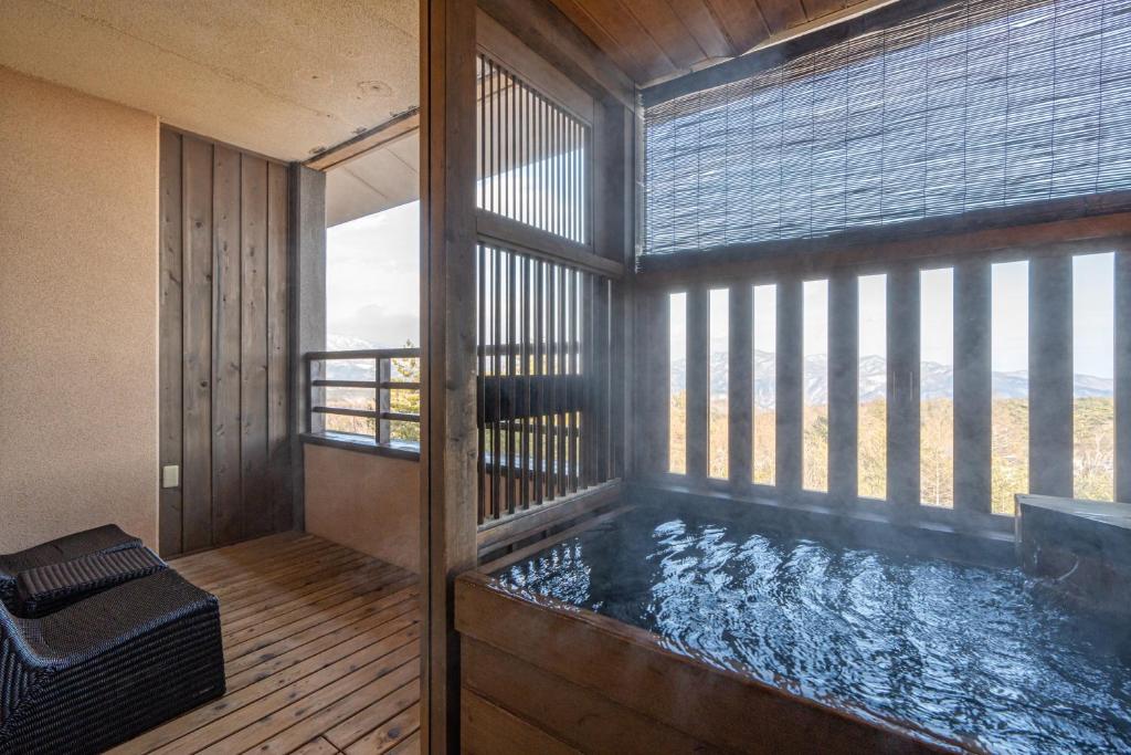 - un bain à remous dans une chambre avec fenêtre dans l'établissement Tokinoniwa, à Kusatsu