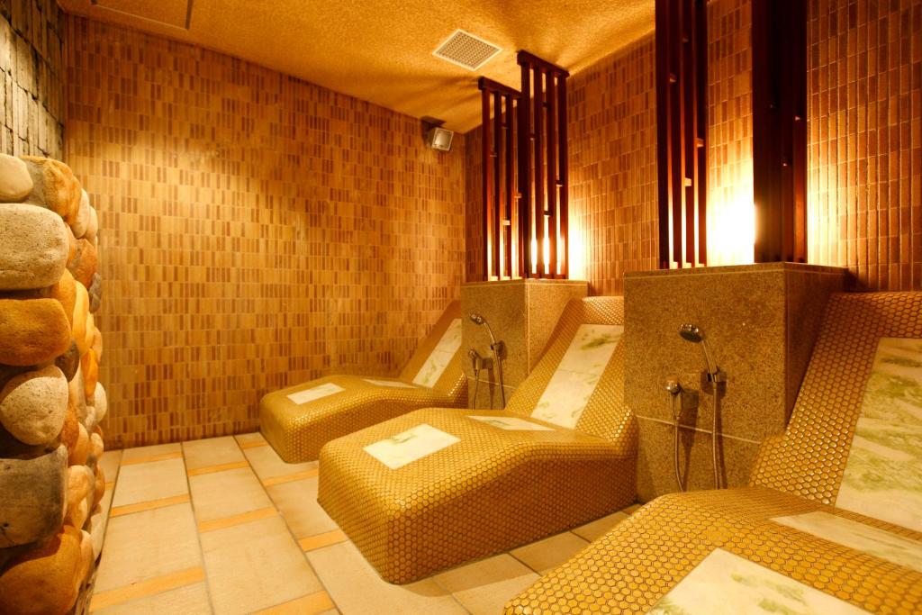 une pièce avec trois chaises dans une pièce carrelée dans l'établissement Tokinoniwa, à Kusatsu