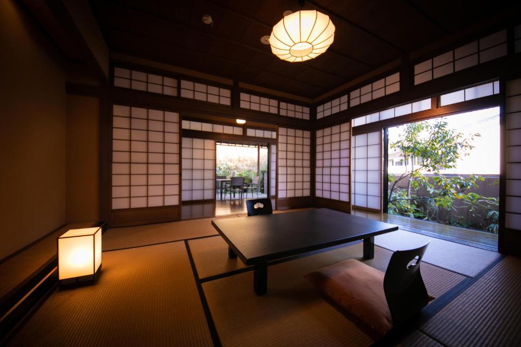 une pièce avec une table, des chaises et une fenêtre dans l'établissement Yufuin Bettei Itsuki, à Yufu