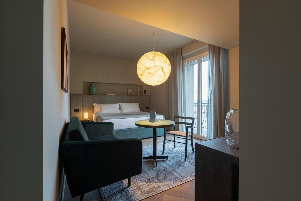 Cette chambre comprend un lit, un canapé et une table. dans l'établissement Hotel Windsor, à Laigueglia