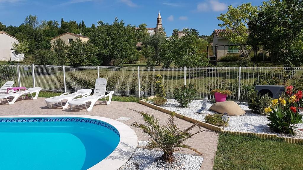 une cour avec une piscine, des chaises et une clôture dans l'établissement Gite Pourquoi Pas, à Montégut-Lauragais