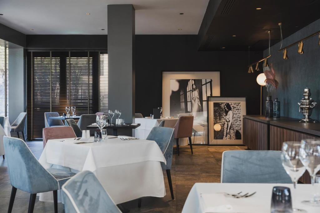 un restaurant avec des tables blanches et des chaises bleues dans l'établissement Coast Hotel & Spa - Adults Only Aperto tutto l'anno, à Milano Marittima