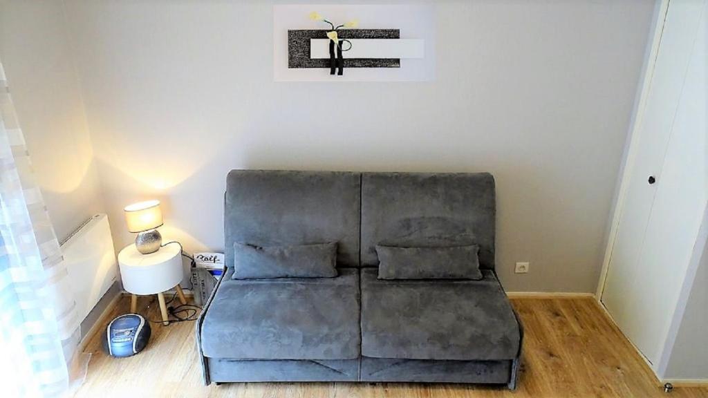 - un canapé dans le salon avec une croix sur le mur dans l'établissement Charmant T2, hypercentre, calme, terrasse, parking, à Luchon