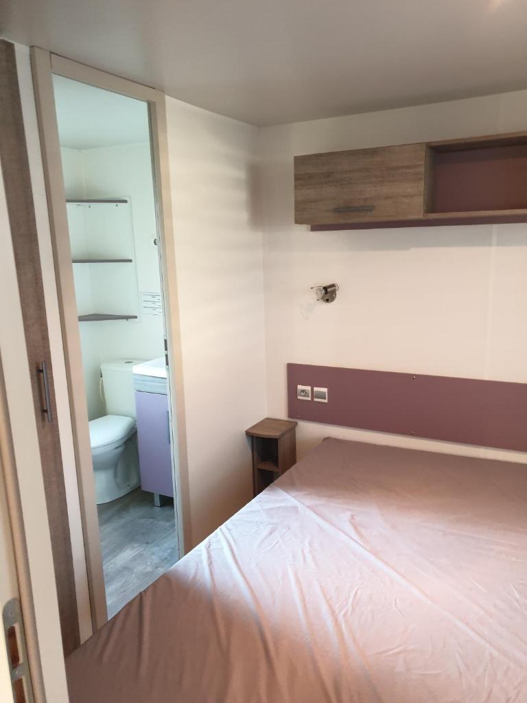 - une chambre avec un lit et une salle de bains avec un miroir dans l'établissement Camping Marvilla Parks - Rivages des Landes - Mobil home 3 chambres, à Aureilhan
