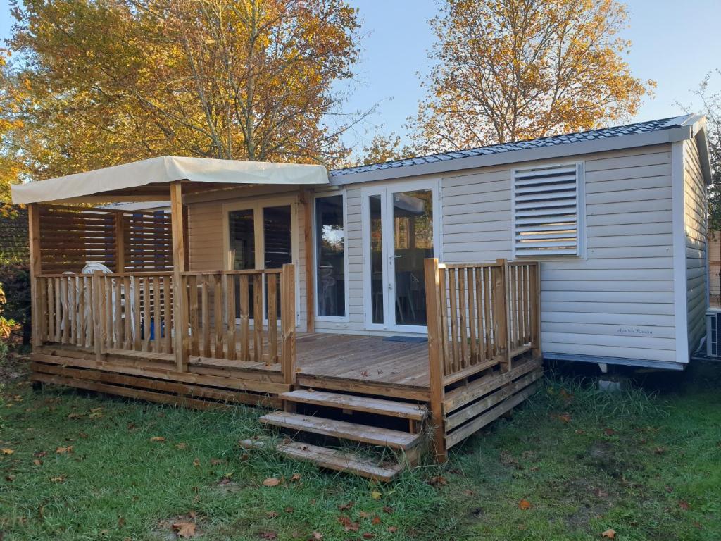 une petite maison avec un porche et une terrasse dans l'établissement Camping Marvilla Parks - Rivages des Landes - Mobil home 3 chambres, à Aureilhan