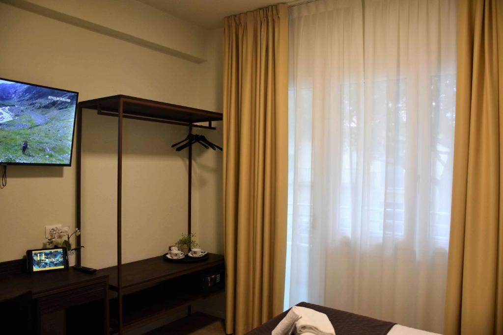 une chambre avec un lit et une fenêtre avec des rideaux dans l'établissement Hotel Suez, à Lido di Jesolo