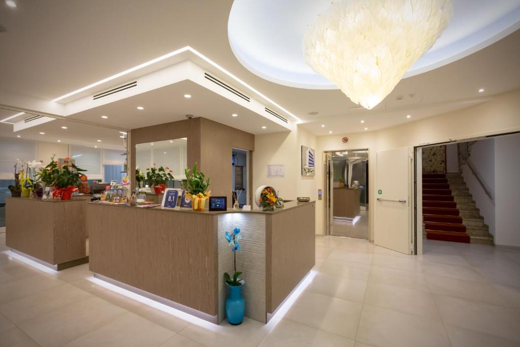 un hall avec un comptoir de réception et un escalier dans l'établissement Hotel Montreal, à Bibione