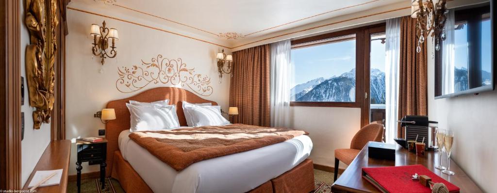 une chambre d'hôtel avec un lit, un bureau et une fenêtre dans l'établissement Hôtel de la Loze, à Courchevel 37 autres photos