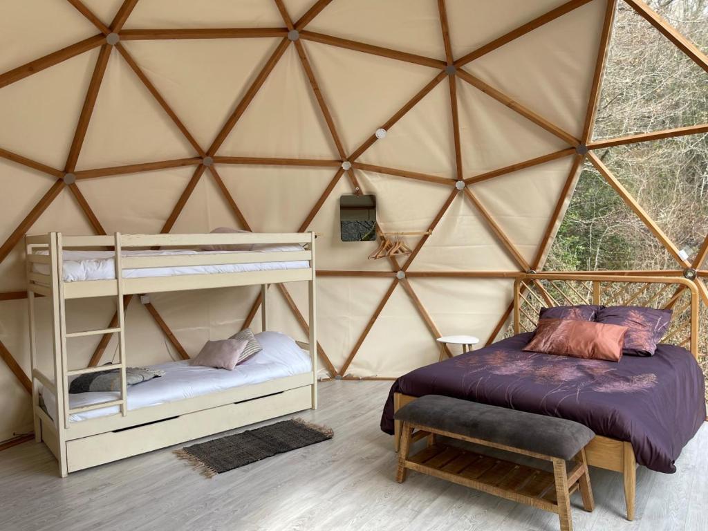 - une chambre avec un lit et un lit dans une yourte dans l'établissement Camping Moulin De Chaules, à Saint-Constant