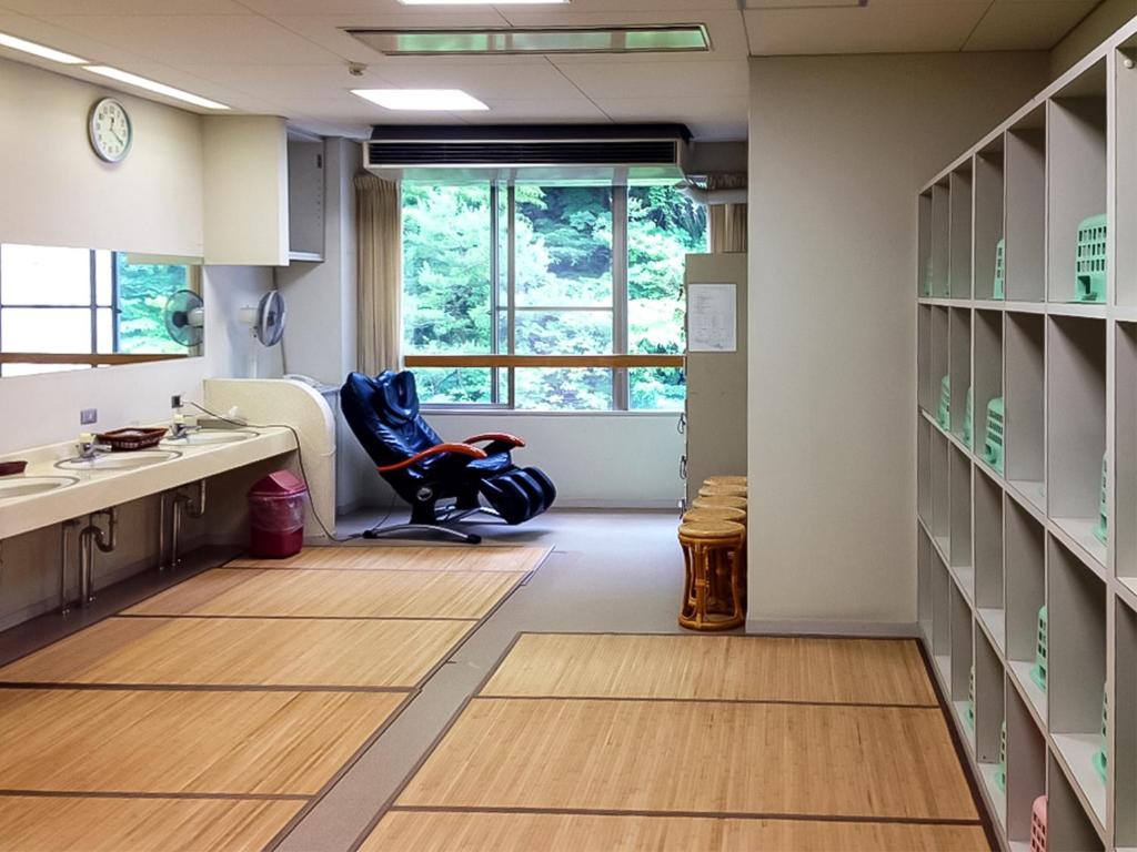 une cuisine avec une chaise, un évier et une fenêtre dans l'établissement Hotel Nosegawa, à Nosegawa