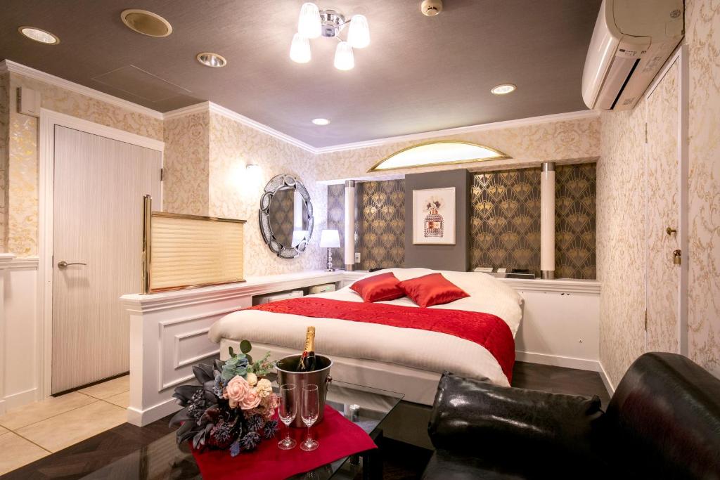 une chambre avec un grand lit avec une couverture rouge dans l'établissement Hotel EXE アネックス 大人専用, à Tokyo