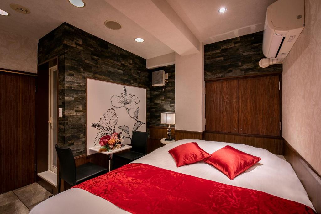 une chambre avec un grand lit avec des oreillers rouges dans l'établissement Hotel EXE アネックス 大人専用, à Tokyo