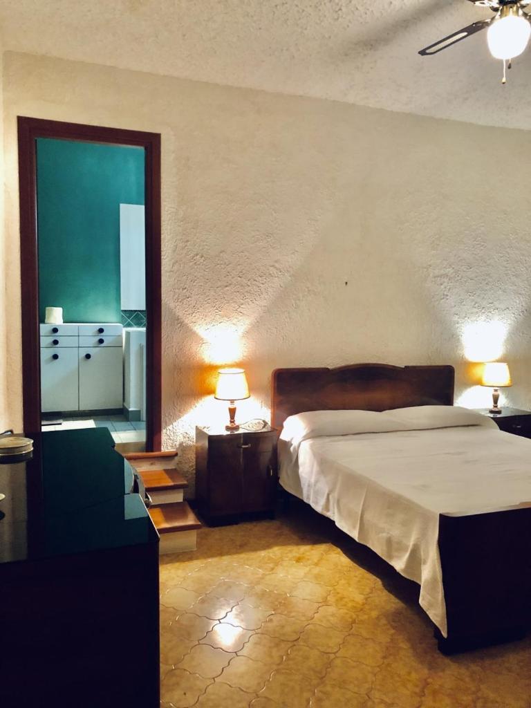 une chambre avec un lit et deux lampes et une fenêtre dans l'établissement Villa Tullio, à Capo dʼOrlando