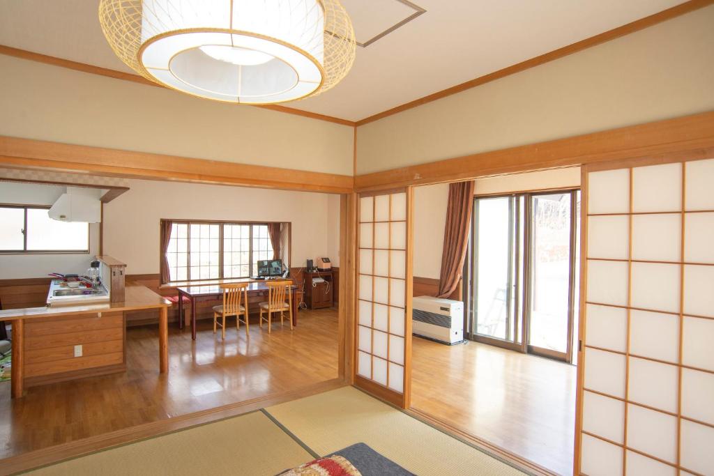 un salon avec une table et une salle à manger dans l'établissement Kusatsu Onsen Eidaya, à Kusatsu