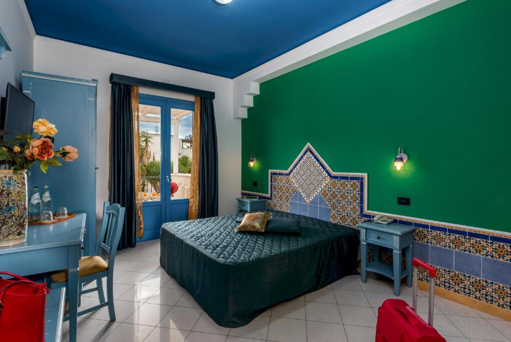 une chambre avec un lit et un mur végétal dans l'établissement Hotel Ristorante Mediterraneo Faro, à San Vito Lo Capo