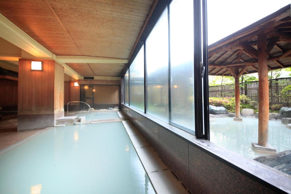 - une piscine dans une maison avec une grande fenêtre dans l'établissement Ryotei Hanayura, à Noboribetsu