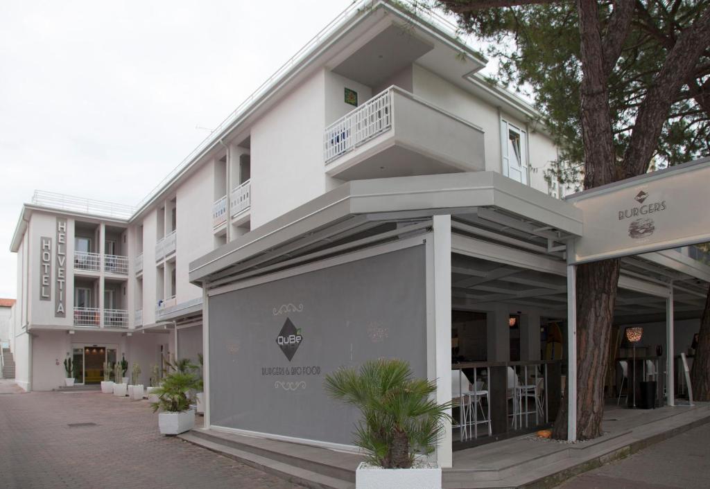 - un bâtiment blanc avec un balcon sur le côté dans l'établissement Hotel Helvetia, à Lido di Jesolo