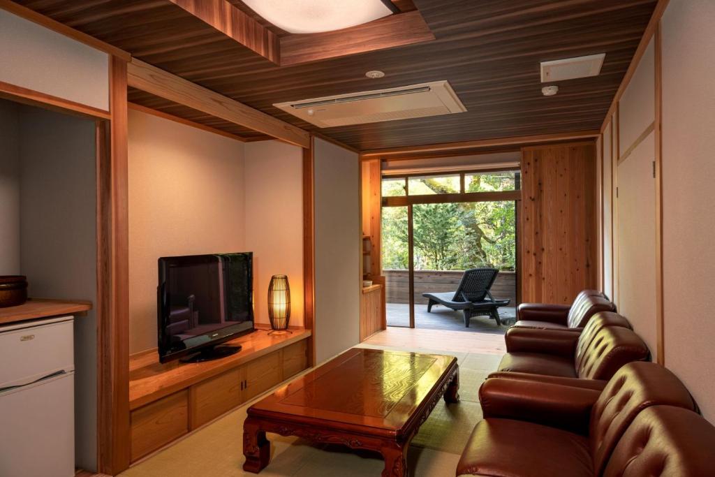 un salon avec un canapé et une télévision dans l'établissement Kakureisen, à Saga