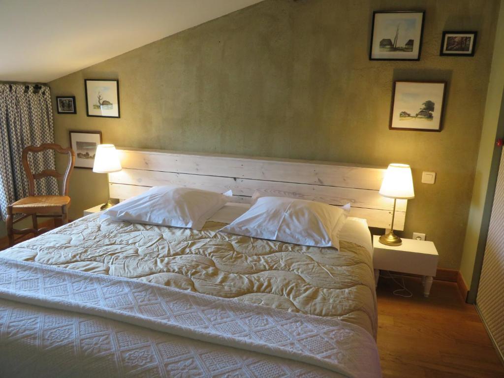 une chambre avec un grand lit avec deux oreillers dans l'établissement Gîte du Pradel, à Saint-Jory