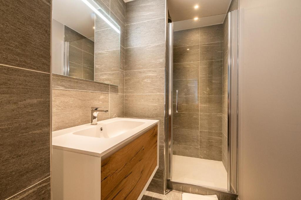 une salle de bain avec un lavabo et une douche dans l'établissement Residence Phoenix Courchevel Village - by EMERALD STAY, à Courchevel