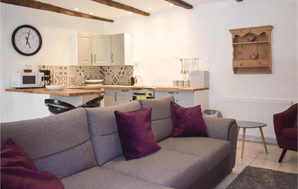 un salon avec un canapé et une cuisine dans l'établissement Cozy Home In Callac De Bretagne, à Callac