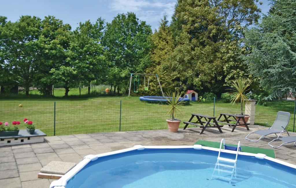 - une piscine dans une cour avec une aire de jeux dans l'établissement Cozy Home In Callac De Bretagne, à Callac