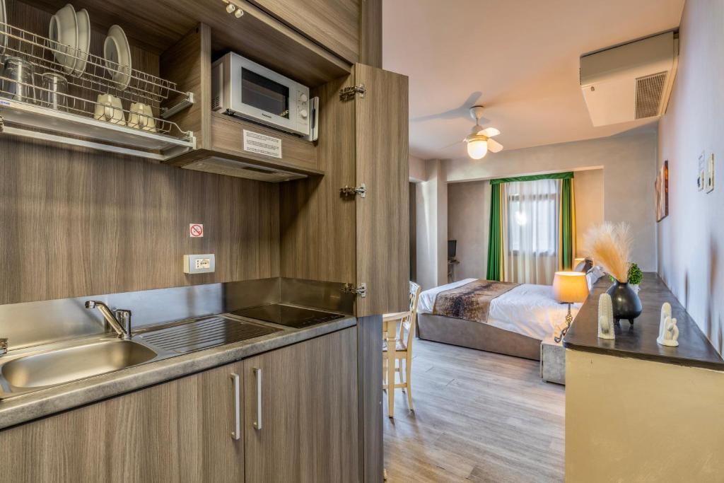 - une cuisine avec évier et un lit dans une chambre dans l'établissement Baba Residences, à Alassio