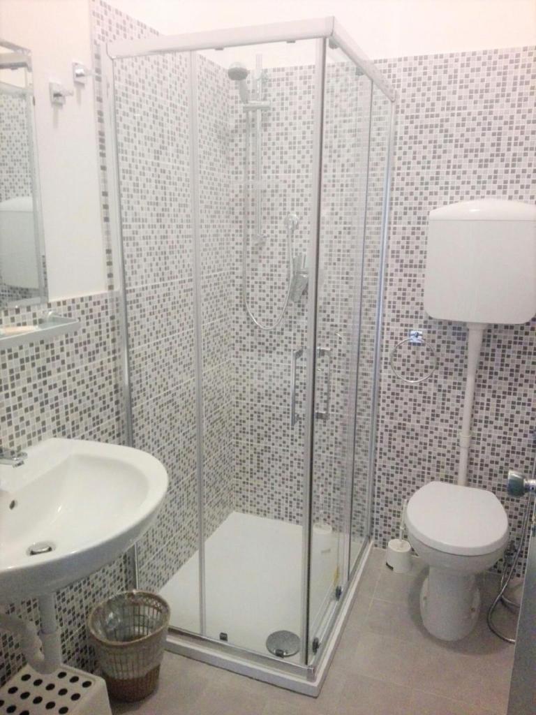 une salle de bain avec une douche avec des toilettes et un lavabo dans l'établissement Hotel Enrica, à Cervia