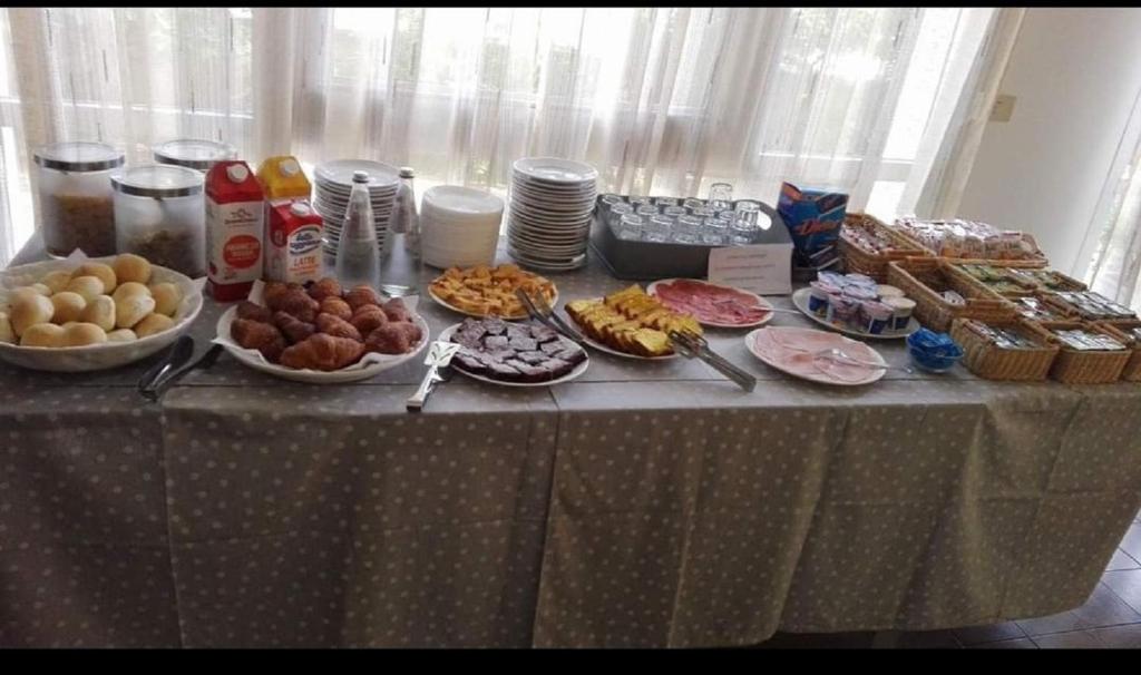 une table contenant de nombreux types de denrées alimentaires différents dans l'établissement Hotel Enrica, à Cervia 16 autres photos