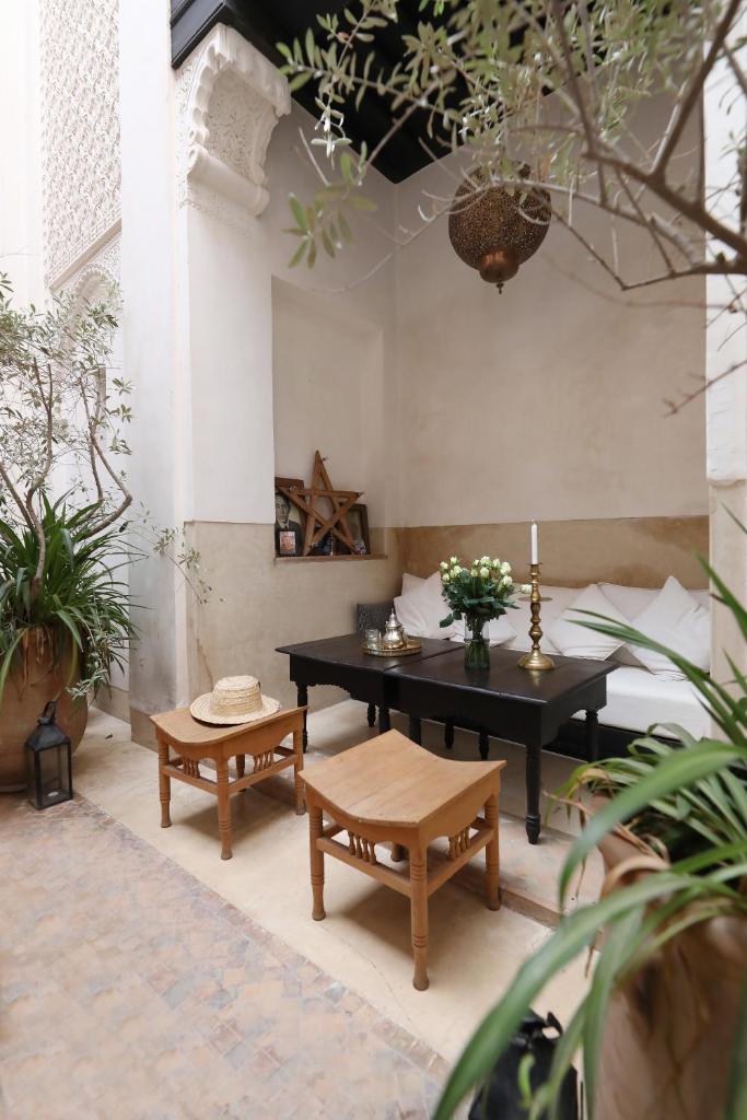 une terrasse avec une table, des bancs et des plantes dans l'établissement Riad Azzouna 13, à Marrakech