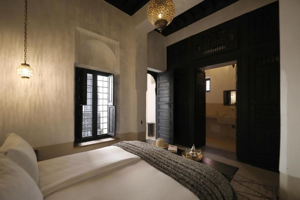 une chambre avec un lit, une fenêtre et un miroir dans l'établissement Riad Azzouna 13, à Marrakech