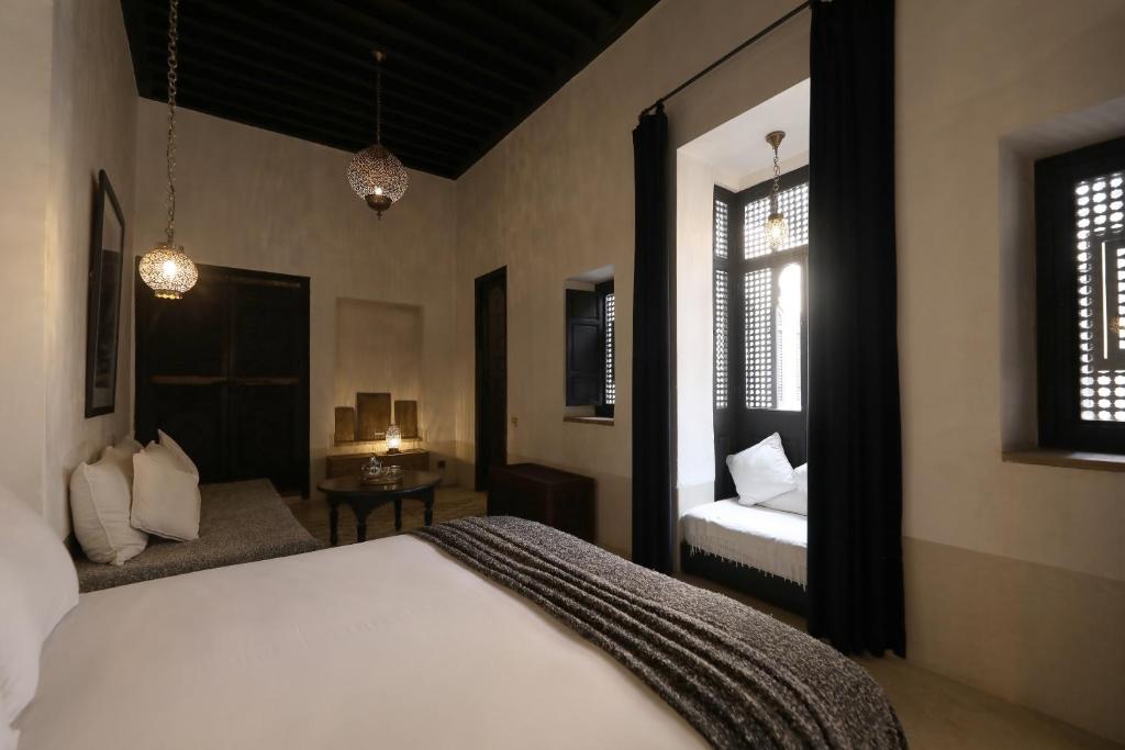 - une chambre avec un lit, un canapé et deux fenêtres dans l'établissement Riad Azzouna 13, à Marrakech