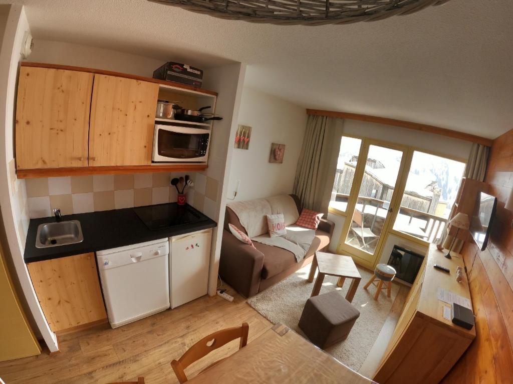 Il comprend une petite cuisine et un salon avec un canapé. dans l'établissement Appartement Studio Avoriaz, à Avoriaz