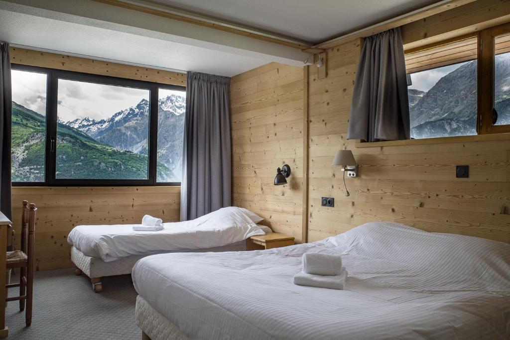 Cette chambre d'hôtel comprend deux lits et offre une vue sur la montagne. dans l'établissement Hôtel Restaurant Saint Roch, à Puy-Saint-Vincent 37 autres photos