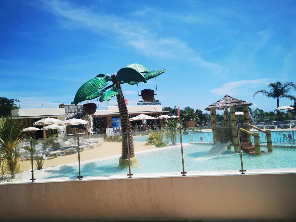 - une piscine avec un palmier dans un complexe dans l'établissement Charmant Mobil home avec Vue mer exceptionnelle, à Saint-Raphaël