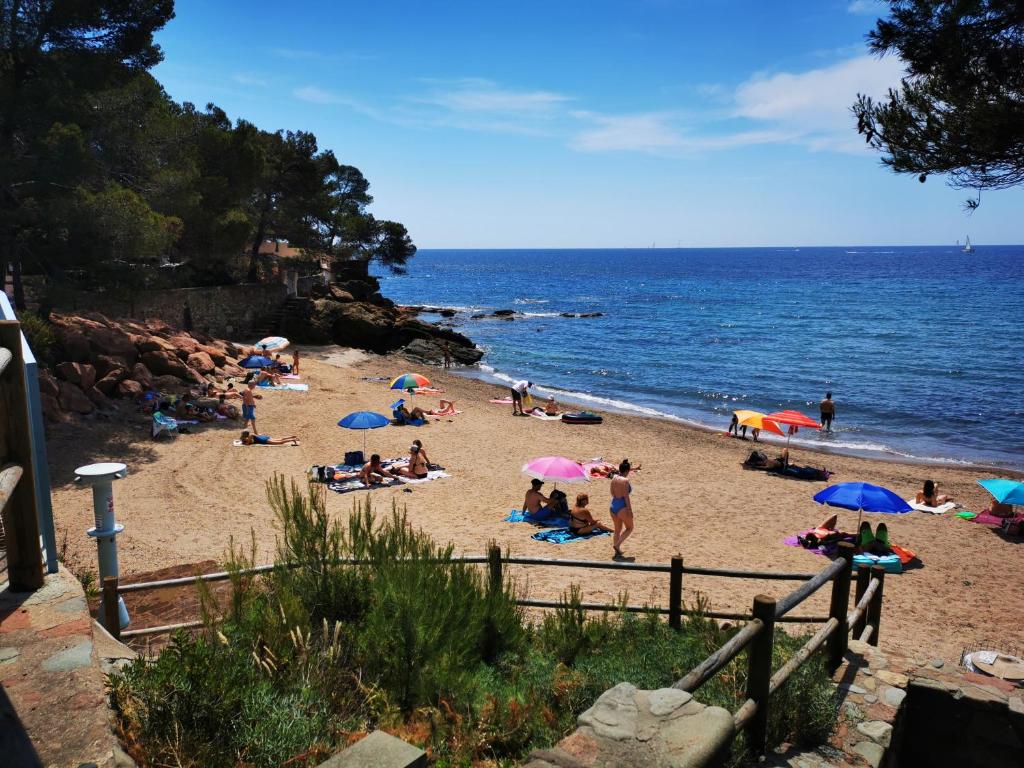 un groupe de personnes sur une plage avec des parasols dans l'établissement Charmant Mobil home avec Vue mer exceptionnelle, à Saint-Raphaël